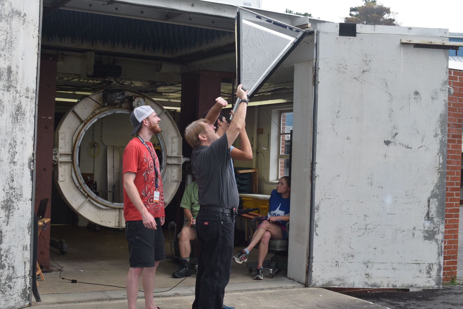 Teachers gathered at a large circular opening in a concrete structure at the Green Bank Observatory