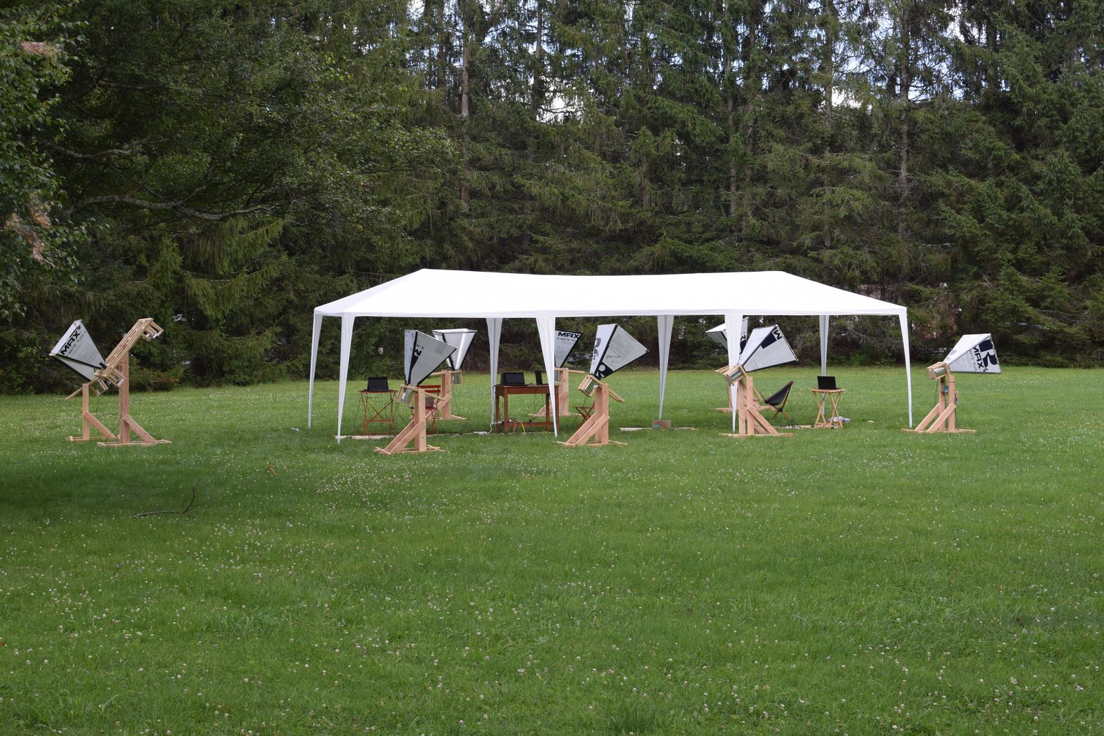 Horn antennas spread across the lawn beside a white canopy at the Green Bank Observatory