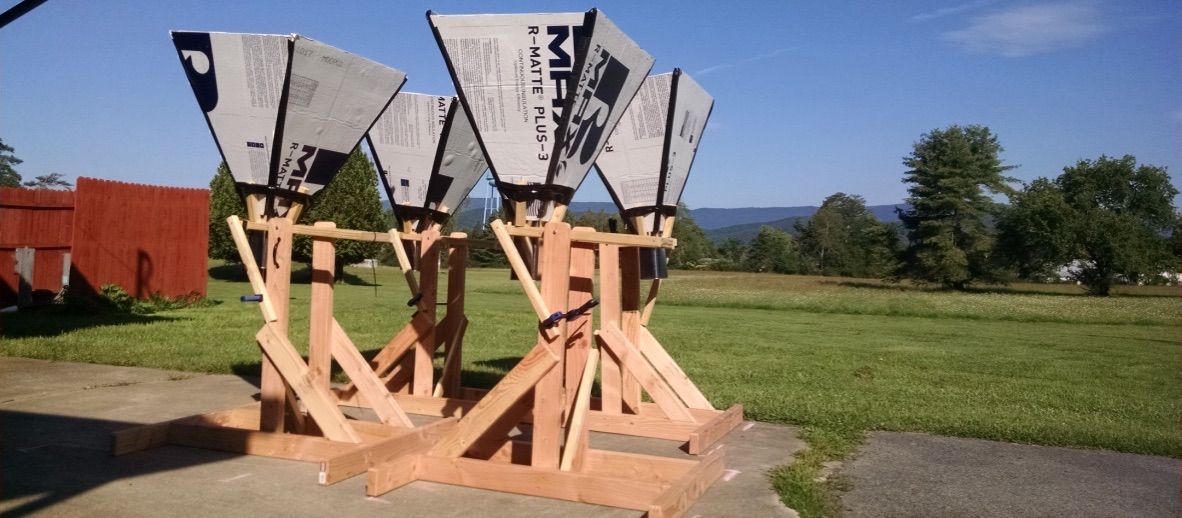 Four teacher-built horn antennas lined up side by side on their wooden mounts as a small aperture array
