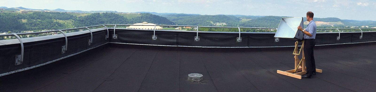 A horn antenna set up on the rooftop of the Engineering Sciences Building at WVU, the valley stretching away behind it